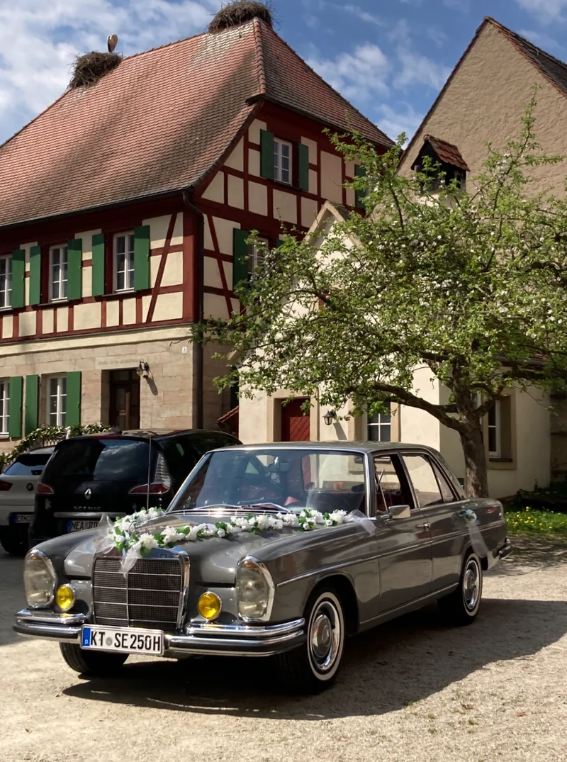 Das perfekte Zusammenspiel aus Hochzeitsauto, Brautpaar und einzigartiger Hochzeitskulisse.